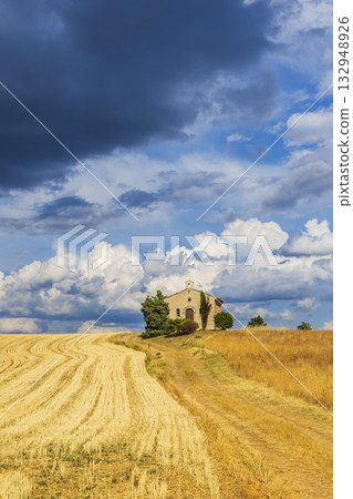 Rural Entrevennes chapel with winding path under dramatic sky Rural Entrevennes chapel with winding path under dramatic sky 132948926