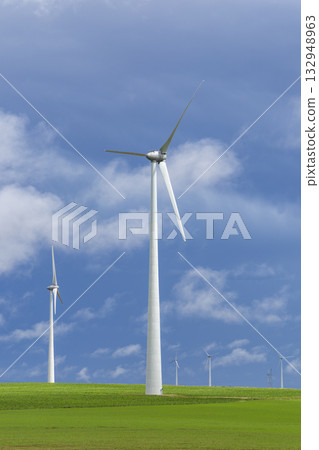 Group of wind turbines in green field under blue sky 132948963