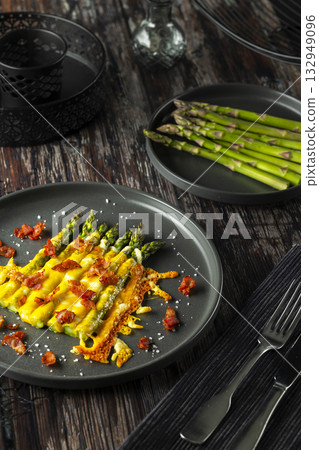 Asparagus spears baking with melted cheese and bacon crumbs Asparagus spears baking with melted cheese and bacon crumbs 132949096