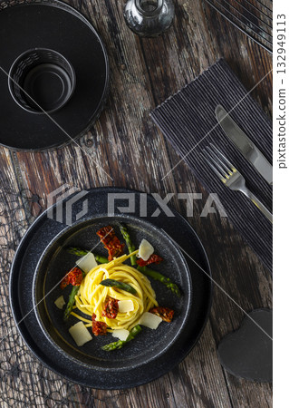 Spaghetti pasta with asparagus, sundried tomatoes and parmesan cheese 132949113