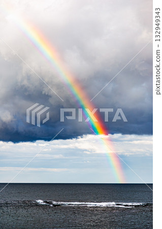 Rainbow stretching into the blue sky and the ocean Rainbow stretching into the blue sky and the ocean 132949343
