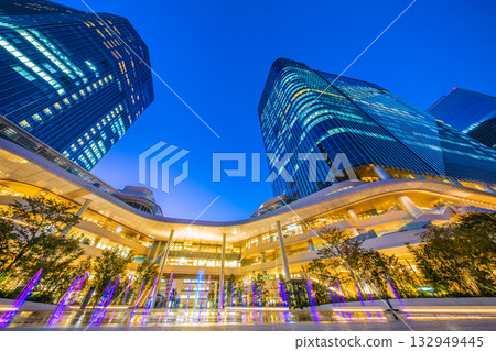 New Tokyo cityscape in Japan. View of Takanawa Gateway City in front of Takanawa Gateway Station. Illuminated fountain. 132949445