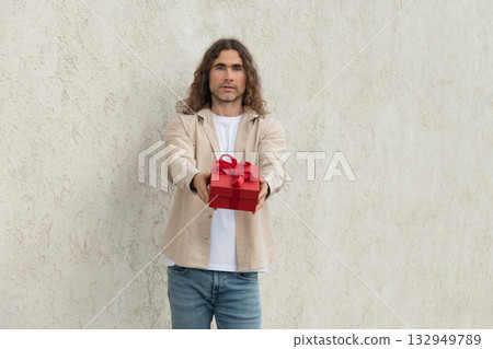 Happy handsome caucasian man giving red gift box with love. Birthday. Romantic surprise and celebration. Greeting card. 132949789