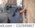 Close-up of female legs with red shoes of high heels. The woman is raising her feet through the window 132949867