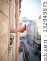 Close-up of female legs with red shoes of high heels. The woman is raising her feet through the window 132949875
