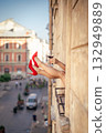 Close-up of female legs with red shoes of high heels. The woman is raising her feet through the window 132949889
