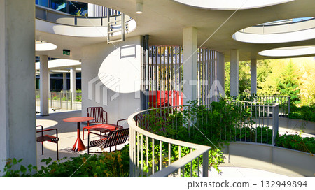 Modern luxury office building.The structure features a glass and concrete walls, showcasing contemporary architecture. The green surroundings of office buildings. Trees and shrubs in the city. Modern luxury office building.The structure features a glass and concrete walls, showcasing contemporary architecture. The green surroundings of office buildings. Trees and shrubs in the city. 132949894