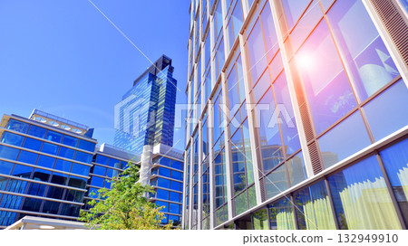 Modern luxury office building.The structure features a glass and concrete walls, showcasing contemporary architecture. The green surroundings of office buildings. Trees and shrubs in the city. Modern luxury office building.The structure features a glass and concrete walls, showcasing contemporary architecture. The green surroundings of office buildings. Trees and shrubs in the city. 132949910