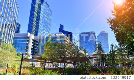 Modern luxury office building.The structure features a glass and concrete walls, showcasing contemporary architecture. The green surroundings of office buildings. Trees and shrubs in the city. Modern luxury office building.The structure features a glass and concrete walls, showcasing contemporary architecture. The green surroundings of office buildings. Trees and shrubs in the city. 132949917