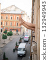 Close-up of female legs with red shoes of high heels. The woman is raising her feet through the window 132949943