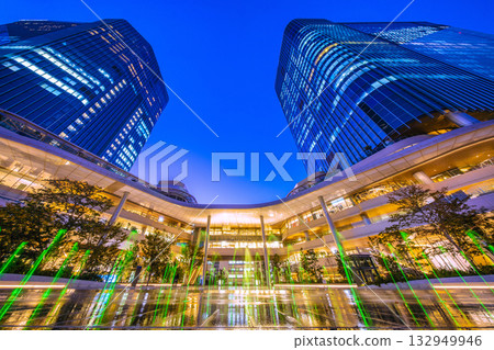 New Tokyo cityscape in Japan. View of Takanawa Gateway City in front of Takanawa Gateway Station. Illuminated fountain. 132949946