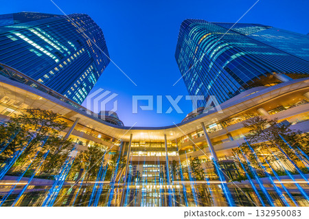 New Tokyo cityscape in Japan. View of Takanawa Gateway City in front of Takanawa Gateway Station. Illuminated fountain. 132950083