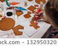 Children decorating gingerbread house with icing and candy, Christmas fun activity 132950320