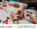 Children decorating gingerbread house with icing and candy, Christmas fun activity 132950322