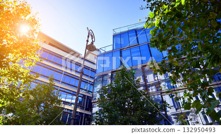 Modern luxury office building.The structure features a glass and concrete walls, showcasing contemporary architecture. The green surroundings of office buildings. Trees and shrubs in the city. 132950493