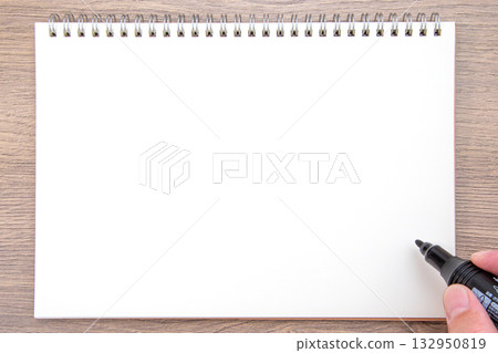 Hand holding a notebook and a black oil-based pen 132950819