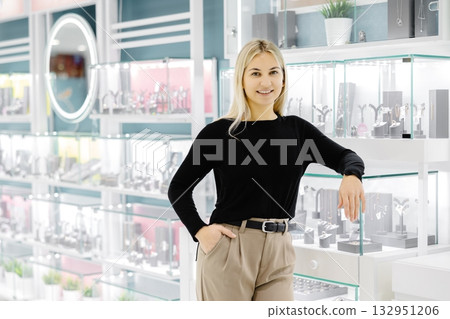 Saleswoman smiling and posing in jewelry shop Saleswoman smiling and posing in jewelry shop 132951206