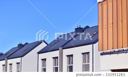 Newly built terraced houses in a residential area. Modern terraced houses on the outskirts of the city. Newly built terraced houses in a residential area. Modern terraced houses on the outskirts of the city. 132951263