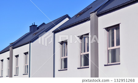 Newly built terraced houses in a residential area. Modern terraced houses on the outskirts of the city. Newly built terraced houses in a residential area. Modern terraced houses on the outskirts of the city. 132951268