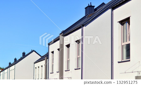 Newly built terraced houses in a residential area. Modern terraced houses on the outskirts of the city. Newly built terraced houses in a residential area. Modern terraced houses on the outskirts of the city. 132951275