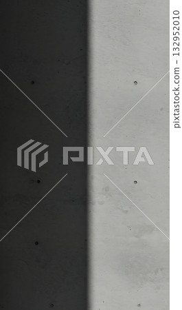 Dramatic contrast of light and shadow across a textured concrete surface, creating a modern, minimalist backdrop for design projects. Dramatic contrast of light and shadow across a textured concrete surface, creating a modern, minimalist backdrop for design projects. 132952010