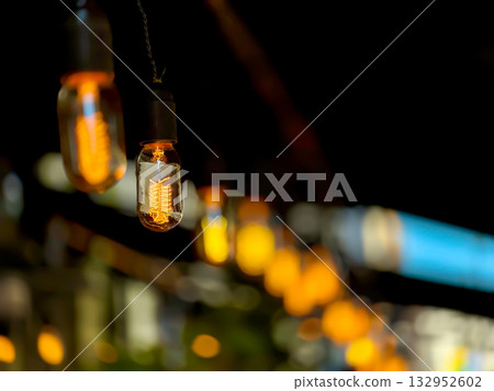 Warm Edison bulbs hanging string lights create cozy night scene for intimate gatherings Warm Edison bulbs hanging string lights create cozy night scene for intimate gatherings 132952602