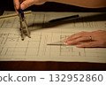 A scene of using a compass for architectural design drawings at home at night 132952860