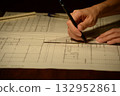 The hands of a Japanese architect drawing architectural drawings at night 132952861