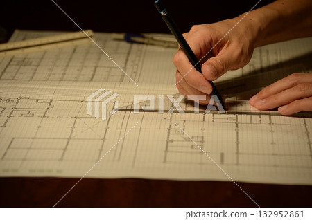 The hands of a Japanese architect drawing architectural drawings at night 132952861