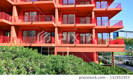 European residential architecture harmonizing with nature. Eco-friendly living in city with greens. Eco apartment building saving energy and fresh air concept.  132952955