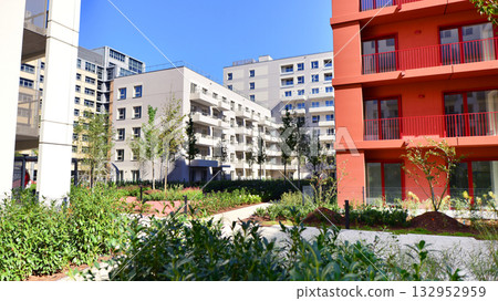 European residential architecture harmonizing with nature. Eco-friendly living in city with greens. Eco apartment building saving energy and fresh air concept. European residential architecture harmonizing with nature. Eco-friendly living in city with greens. Eco apartment building saving energy and fresh air concept. 132952959