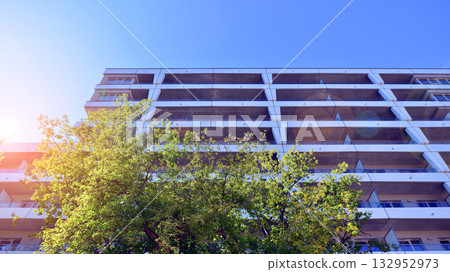 European residential architecture harmonizing with nature. Eco-friendly living in city with greens. Eco apartment building saving energy and fresh air concept.  132952973