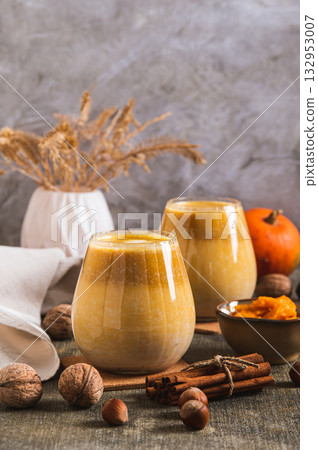 Warming pumpkin nut latte in glasses on the table vertical view Warming pumpkin nut latte in glasses on the table vertical view 132953007