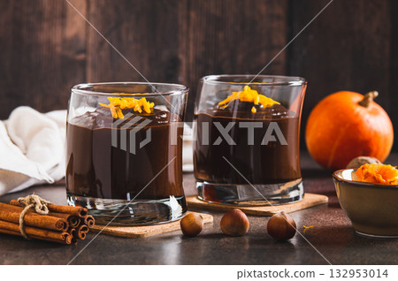 Chocolate pumpkin mousse with orange zest in glasses on the table 132953014