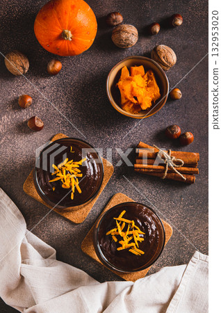 Autumn chocolate pumpkin dessert in glasses on the table top and vertical view 132953020