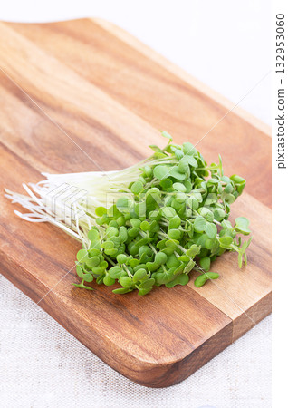 Mustard microgreens, bunch of fresh white mustard sprouts, on wooden cutting board, on linen. Seedlings and shoots of Sinapis alba, also yellow mustard, a spicy herb, used in salads, as garnish, etc. Mustard microgreens, bunch of fresh white mustard sprouts, on wooden cutting board, on linen. Seedlings and shoots of Sinapis alba, also yellow mustard, a spicy herb, used in salads, as garnish, etc. 132953060