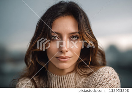 Portrait of a woman with long hair and striking eyes outdoors during cloudy weather 132953208