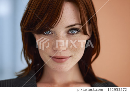 Portrait of a young woman with red hair and blue eyes smiling against a soft background 132953272