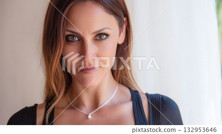 Portrait of a woman with confident expression and natural beauty indoors in soft lighting 132953646