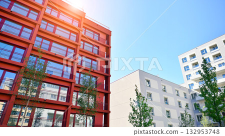 European residential architecture harmonizing with nature. Eco-friendly living in city with greens. Eco apartment building saving energy and fresh air concept.  132953748