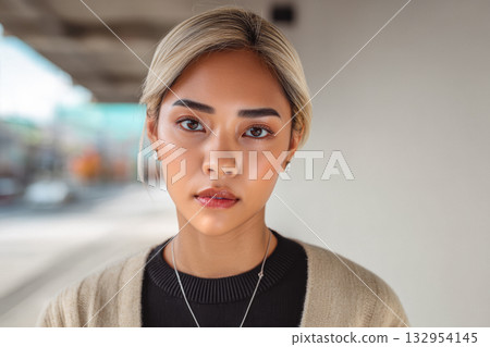 Young woman with light brown hair posing confidently in an urban setting during daylight hours 132954145