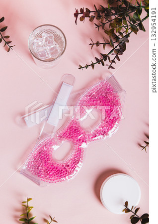 A trendy cryo skincare ice mask gadget on a pink table top and vertical view 132954191