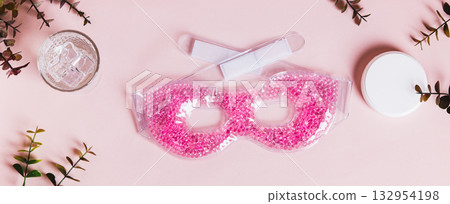 A trendy cryo skincare ice mask gadget on a pink table top view web banner 132954198