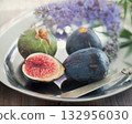 Whole and sliced figs on a plate and on a wooden table. Beautiful still life 132956030