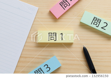 There are sticky notes on the desk with questions 1, 2, 3, and 4 written on them. There are sticky notes on the desk with questions 1, 2, 3, and 4 written on them. 132956150