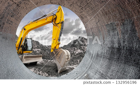 A vibrant yellow excavator works diligently at a construction site, digging into the earth while framed by a cylindrical pipe 132956196