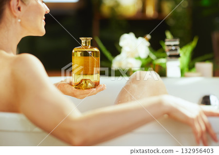 Woman Relaxing in Bathtub with Bath Oil Woman Relaxing in Bathtub with Bath Oil 132956403