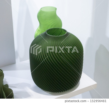 Object printed on 3D printer close up. Model printed on 3D printer from molten plastic. Vase printed on 3D printer from molten plastic of green color. 3D printing technology. Additive FDM technologies Object printed on 3D printer close up. Model printed on 3D printer from molten plastic. Vase printed on 3D printer from molten plastic of green color. 3D printing technology. Additive FDM technologies 132956481