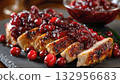 Sliced roast turkey with cranberry sauce and berries on a black slate board, a seasonal traditional dish for Thanksgiving and Christmas 132956683