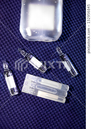 Medical Ampoules and Saline Solution on Blue Fabric Medical Ampoules and Saline Solution on Blue Fabric 132956845